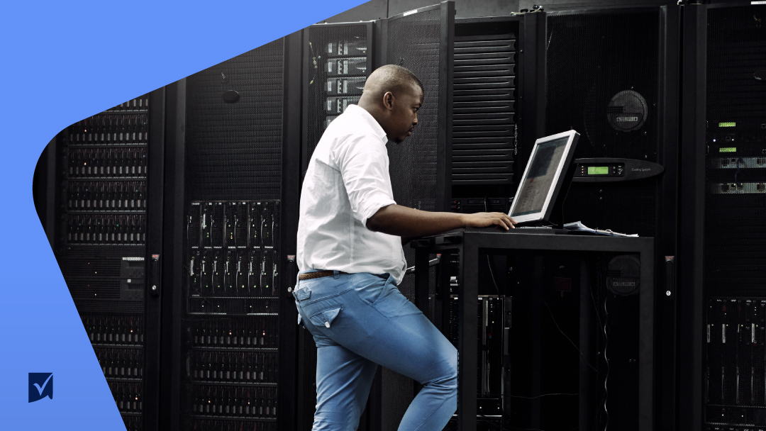 A black man working on his laptop with an IT system